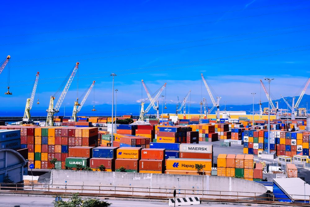 Contêineres e guindastes em um porto de comércio marítimo.